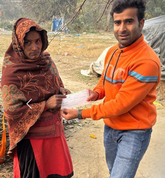 Volunteer handing relief cheque to a woman